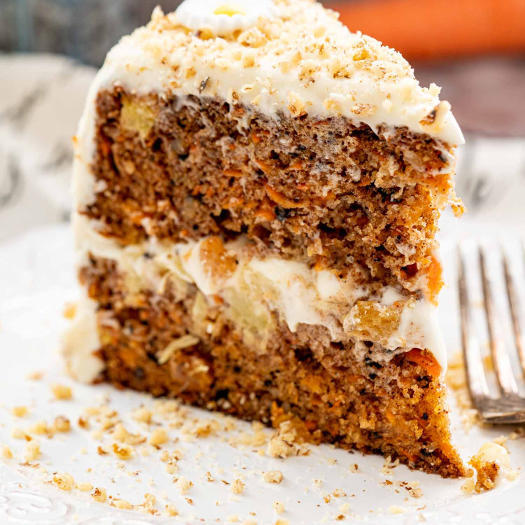 a slice of carrot cake on a white plate.