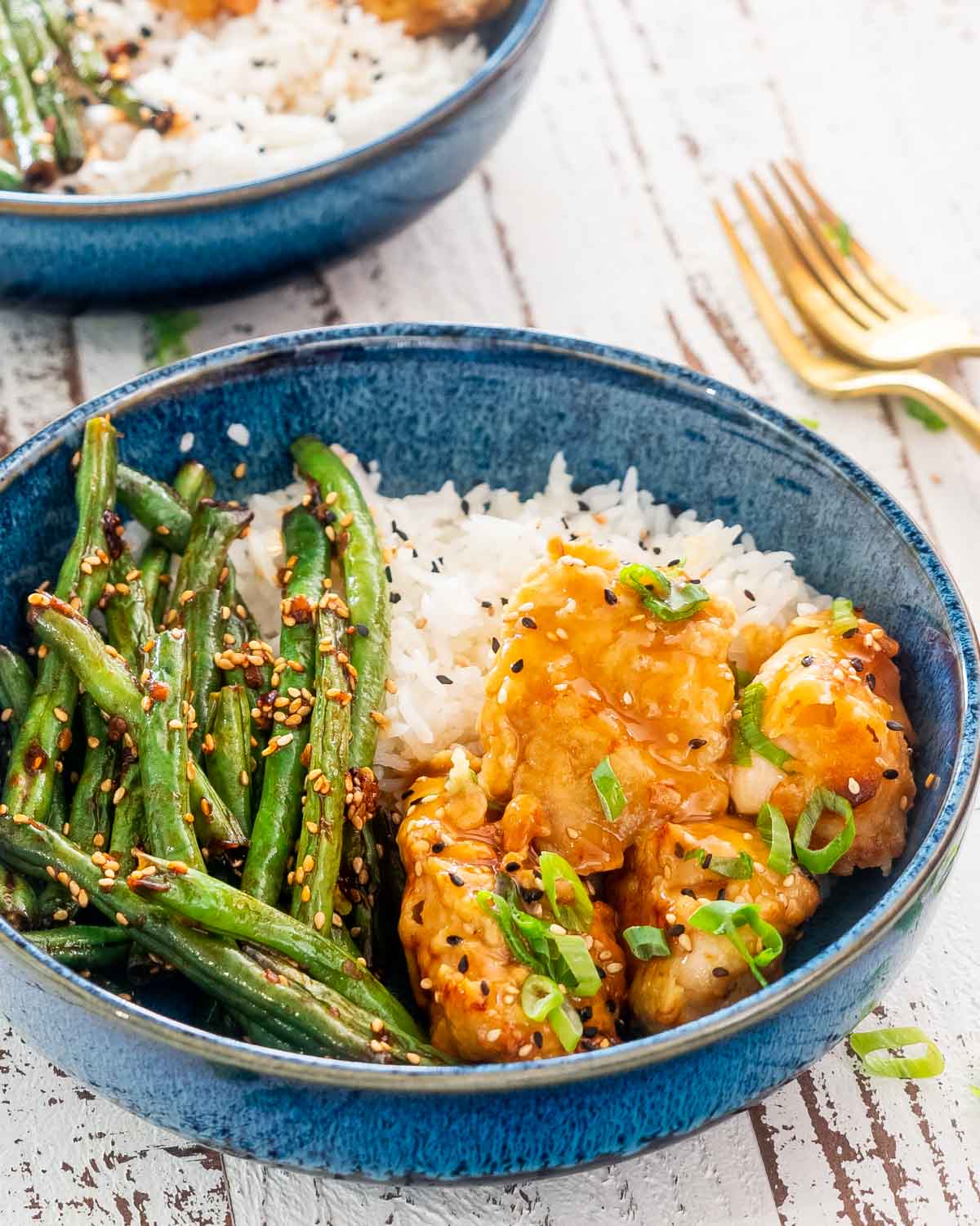 lemon chicken with asian green beans in a blue bowl.