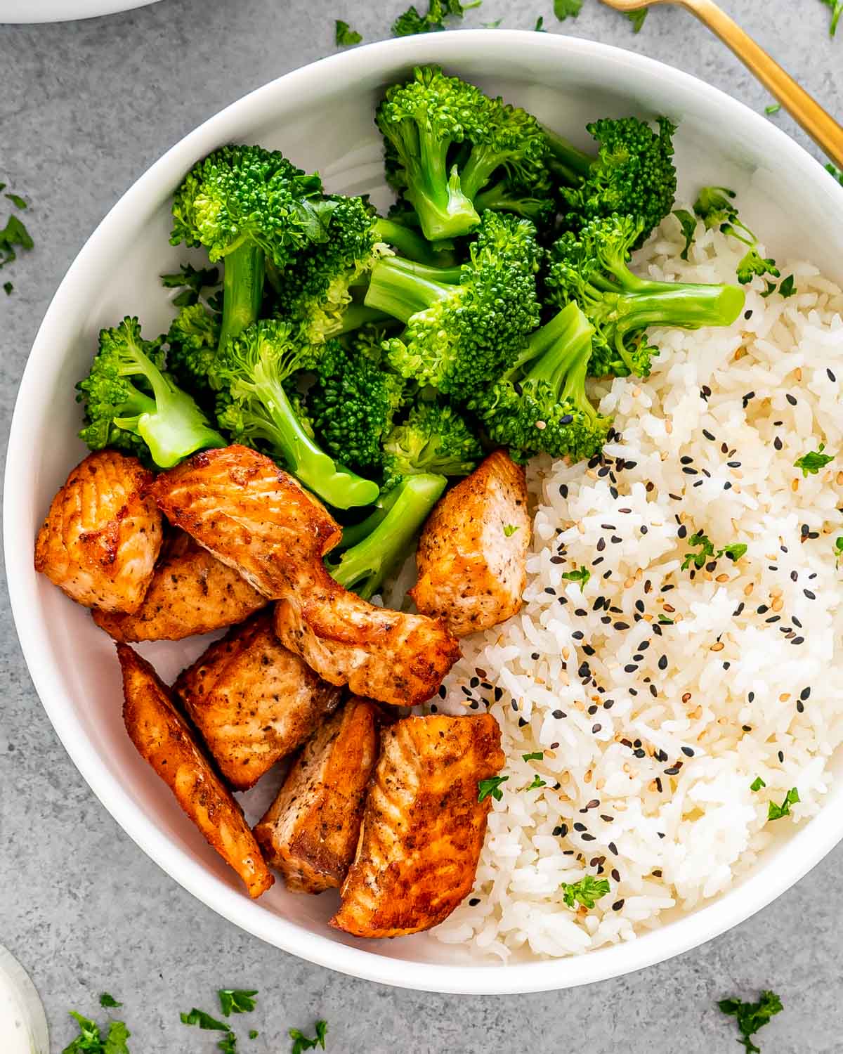 air fryer salmon bites in a white bowl with rice and broccoli