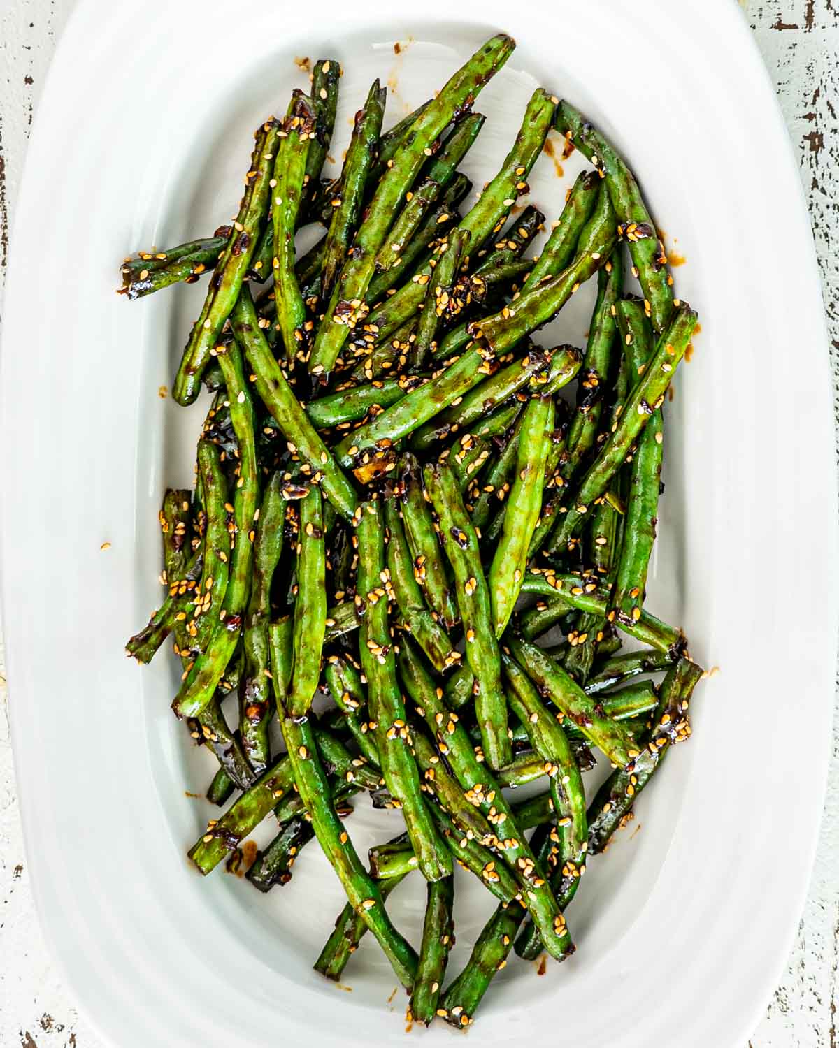 freshly made asian style green beans in a white platter.