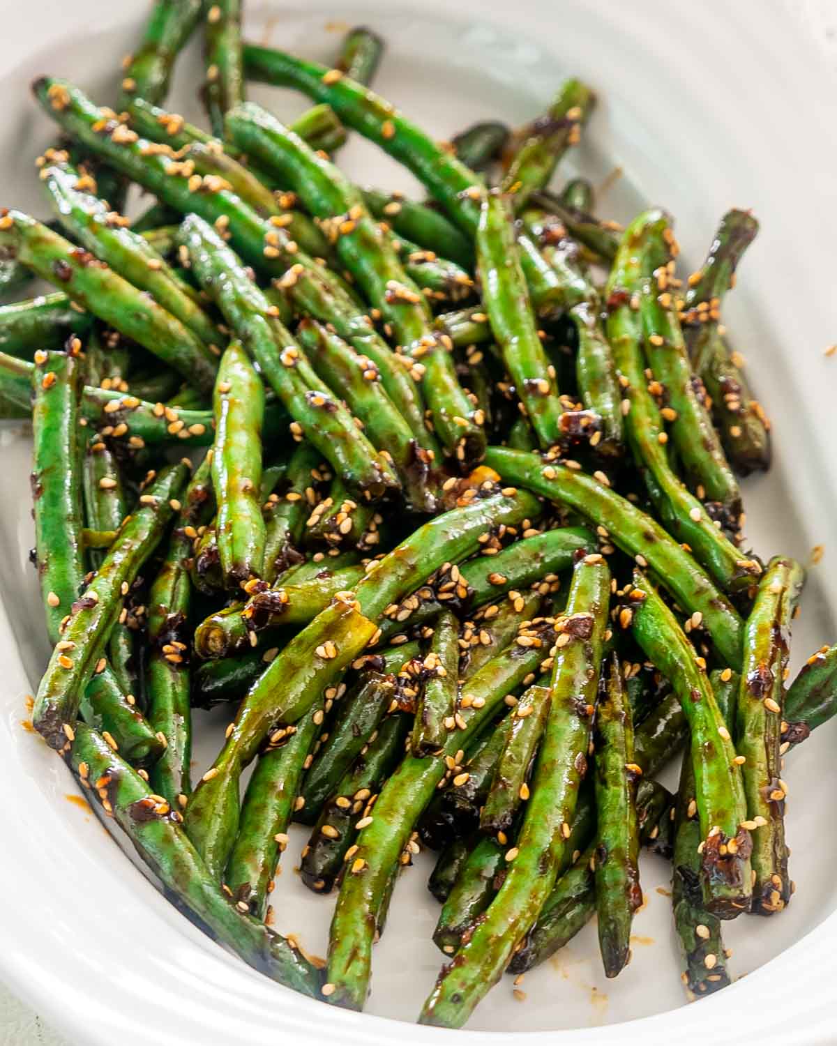 freshly made asian style green beans in a white platter.