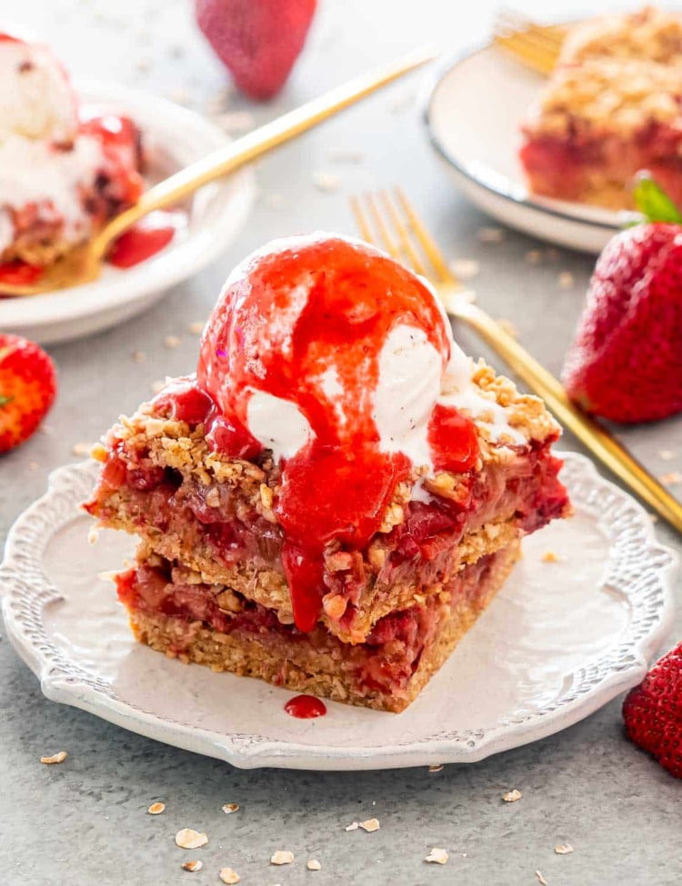 two strawberry rhubarb bars with a scoop of ice cream.