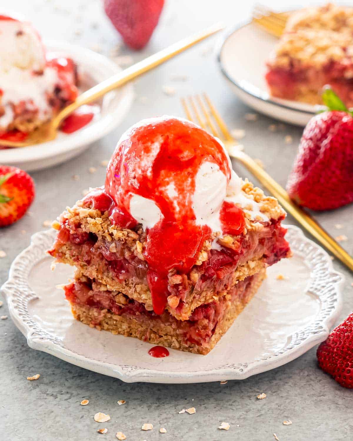 two strawberry rhubarb bars with a scoop of ice cream.