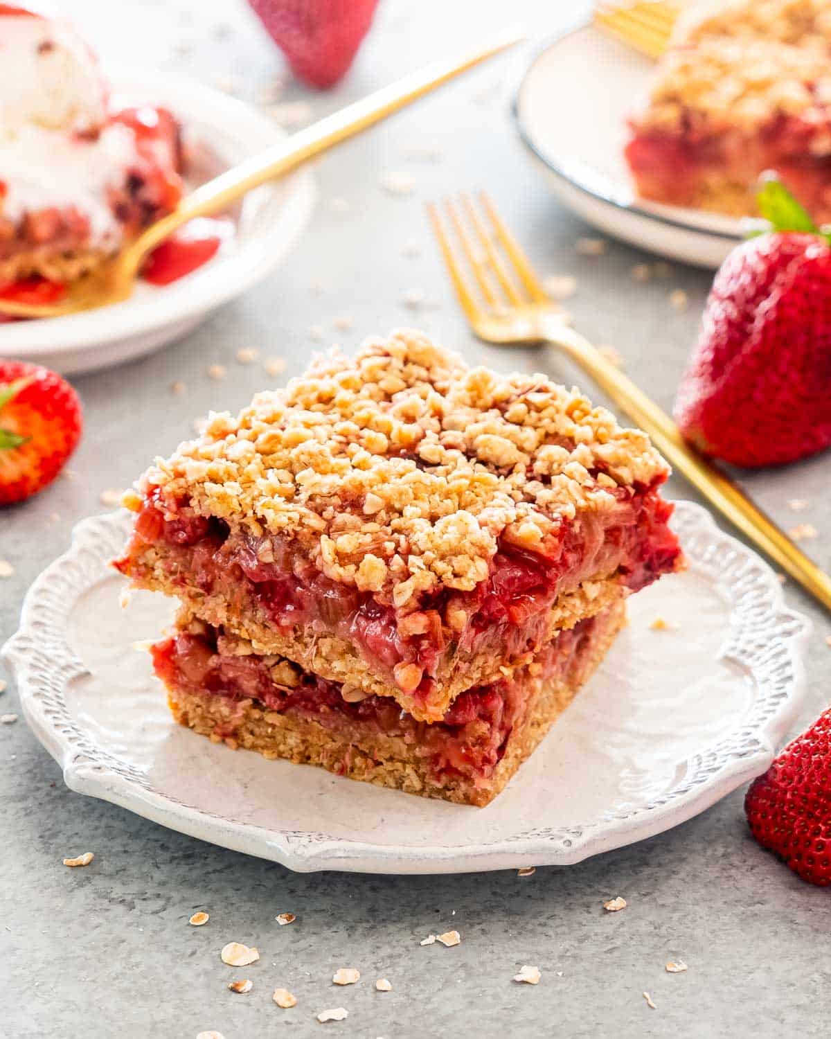 two strawberry rhubarb bars on a white plate.