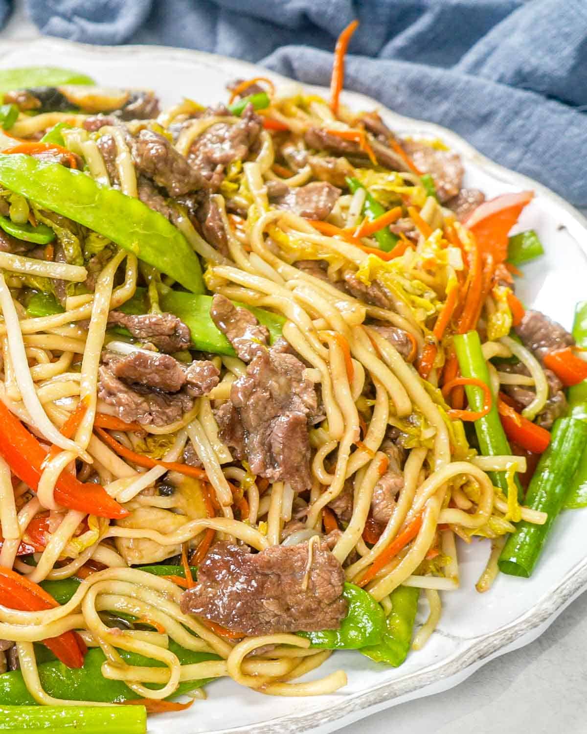 beef lo mein in a white serving platter.