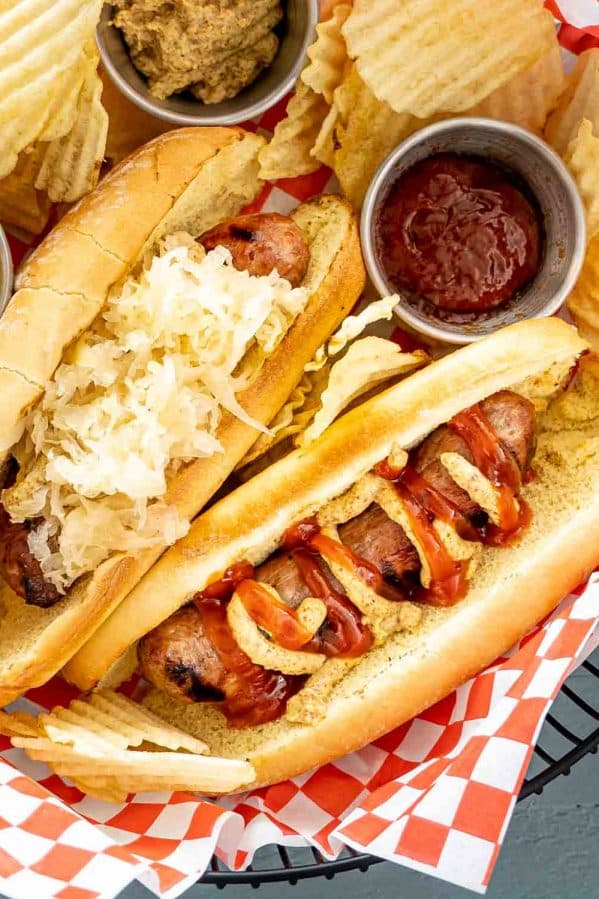 grilled bratwurst in a basket with chips.