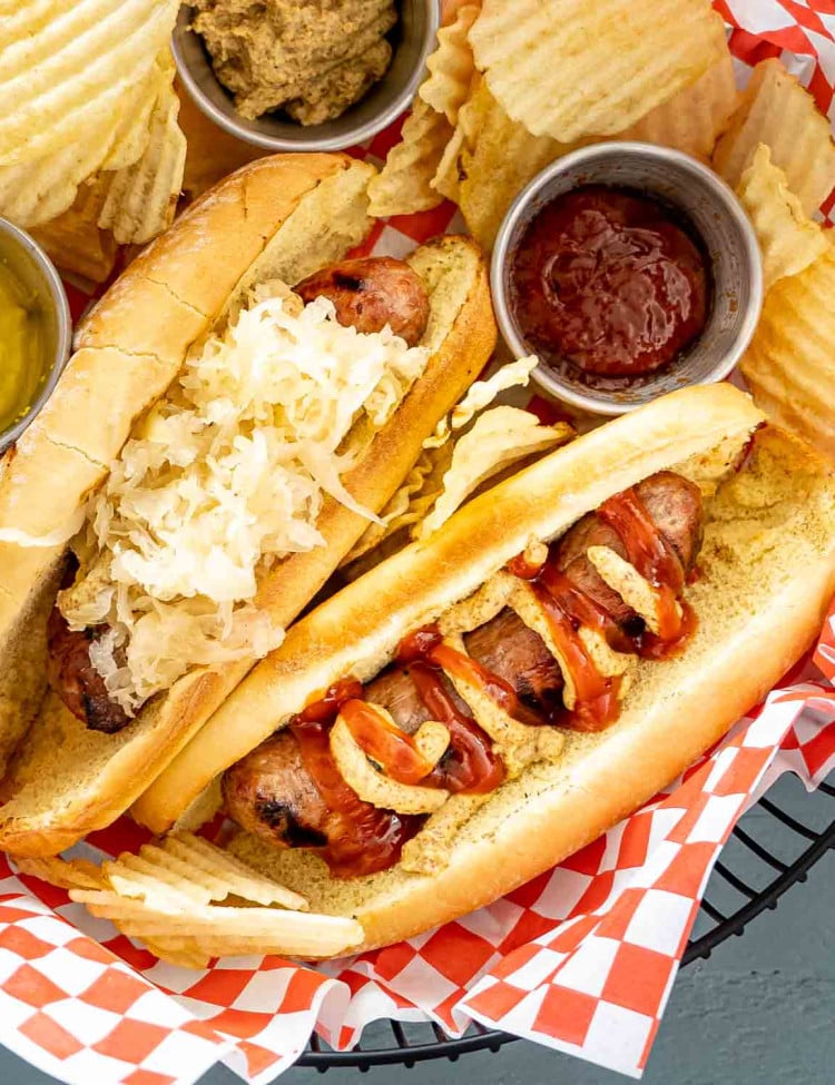 grilled bratwurst in a basket with chips.