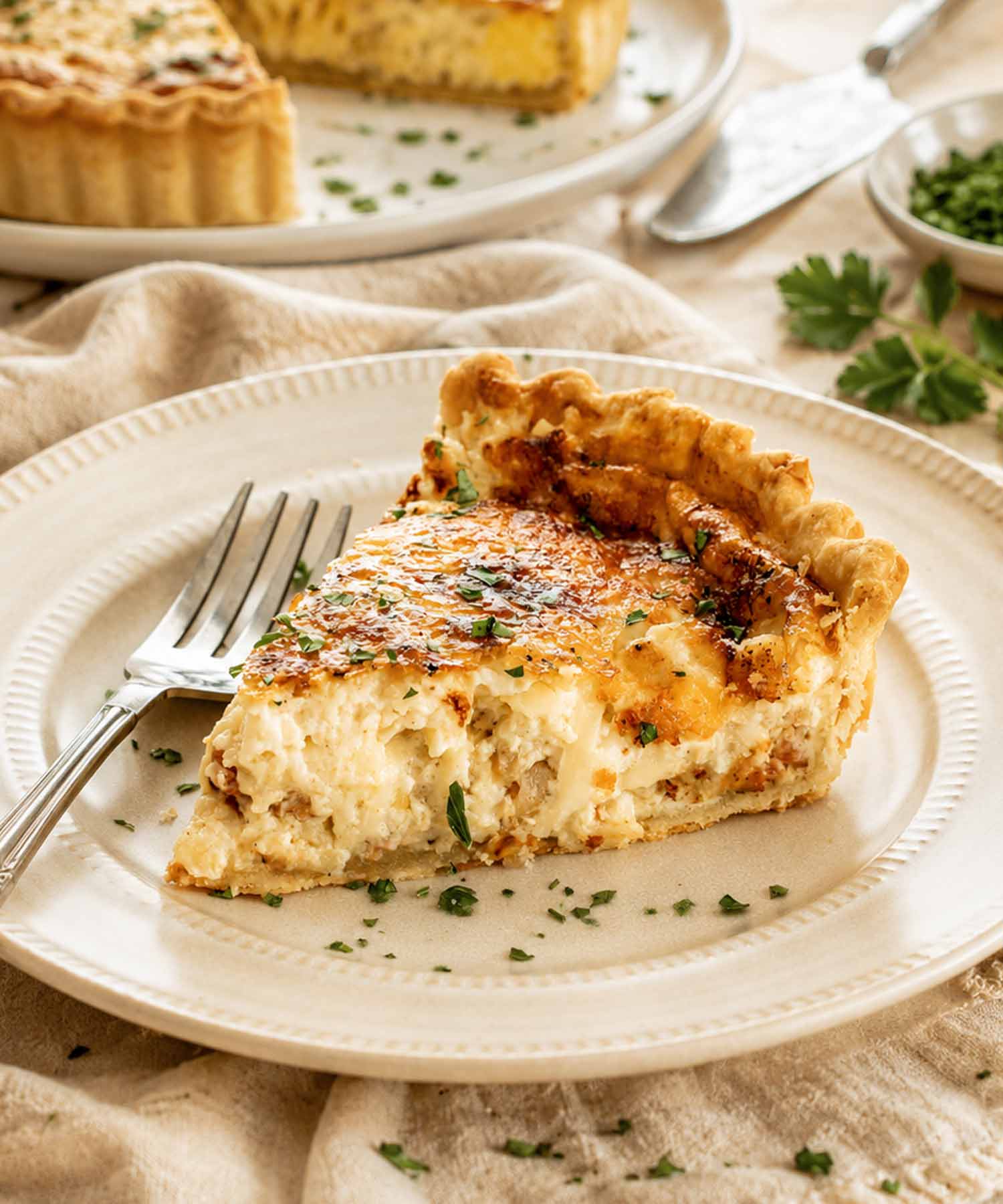 a slice of quiche lorraine on a plate.
