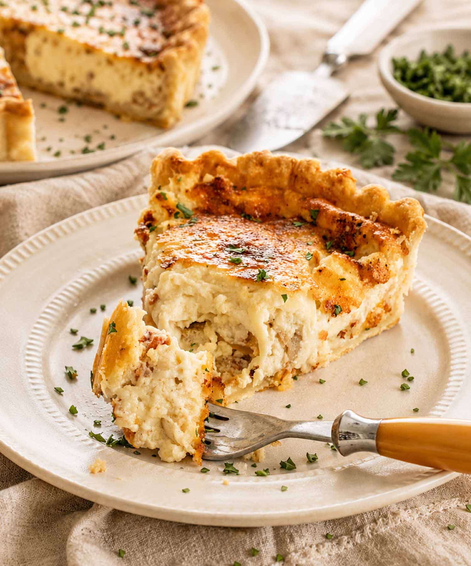 a slice of quiche lorraine on a plate.
