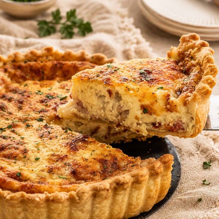 side view shot of a slice of quiche being lifted from the quiche lorraine.
