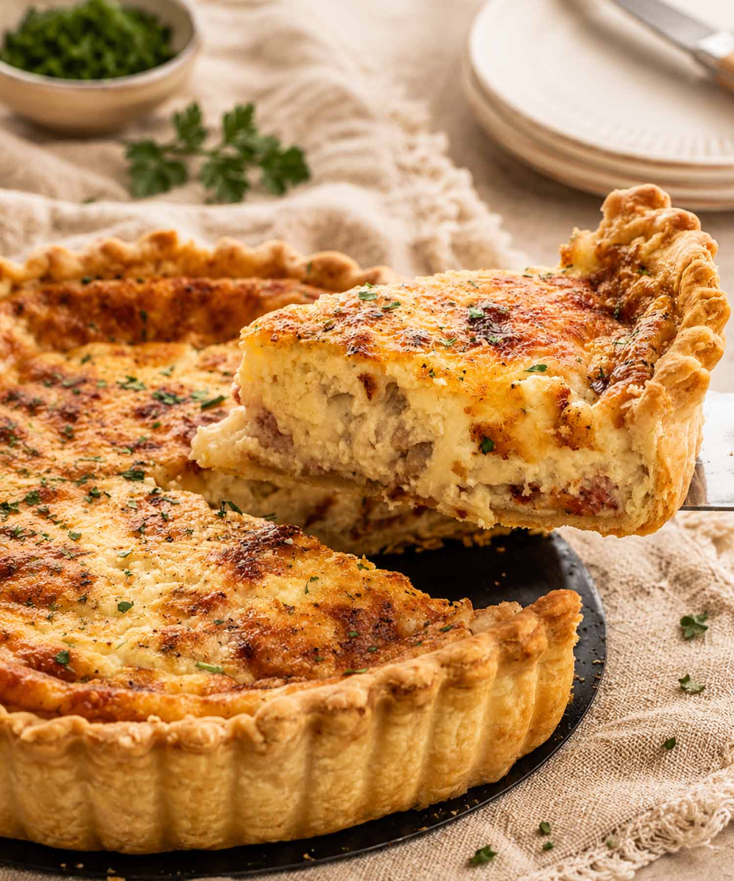 side view shot of a slice of quiche being lifted from the quiche lorraine.