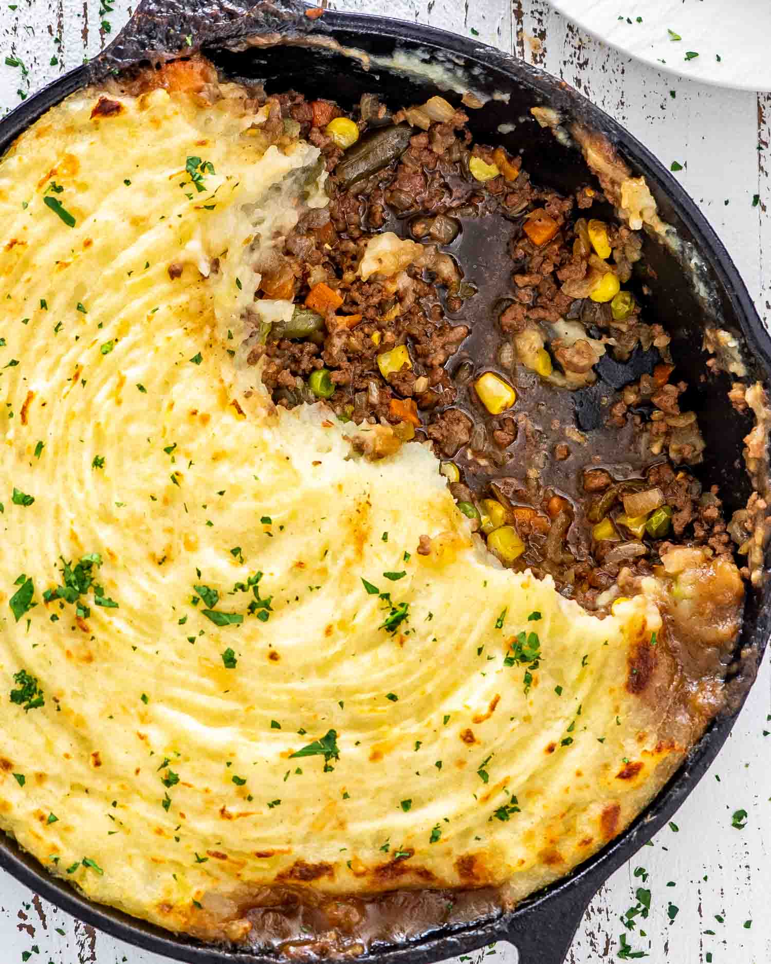 skillet shepherd's pie in a cast iron skillet with a portion taken out.