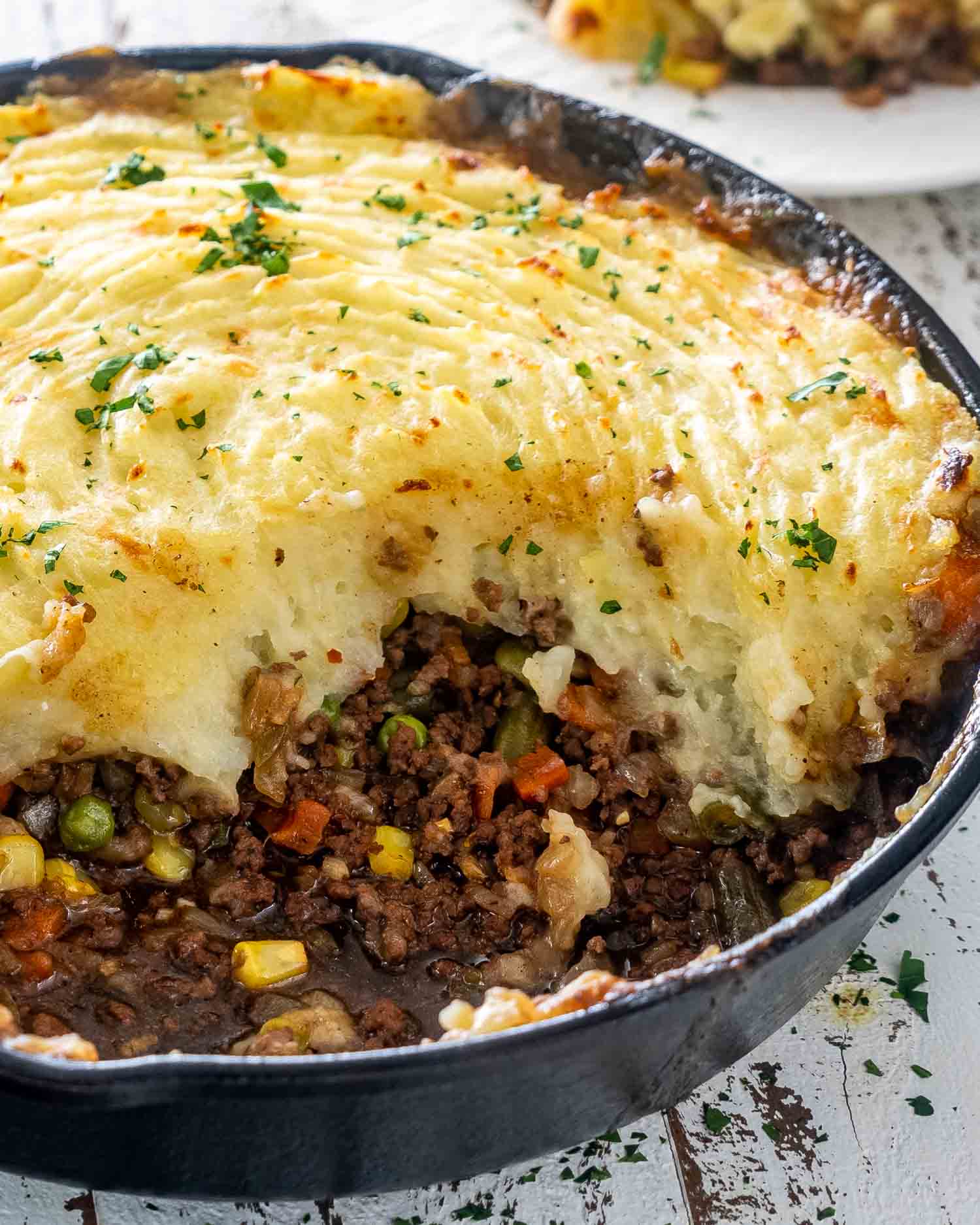 skillet shepherd's pie in a cast iron skillet with a portion taken out.