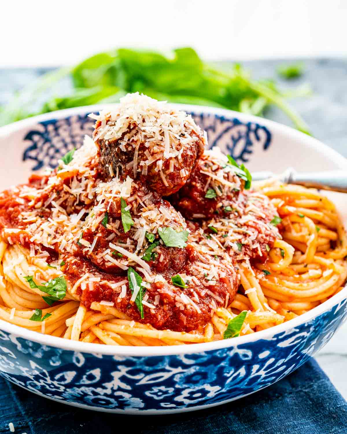 a plated loaded with freshly made spaghetti and meatballs and topped with freshly grated parmesan cheese.