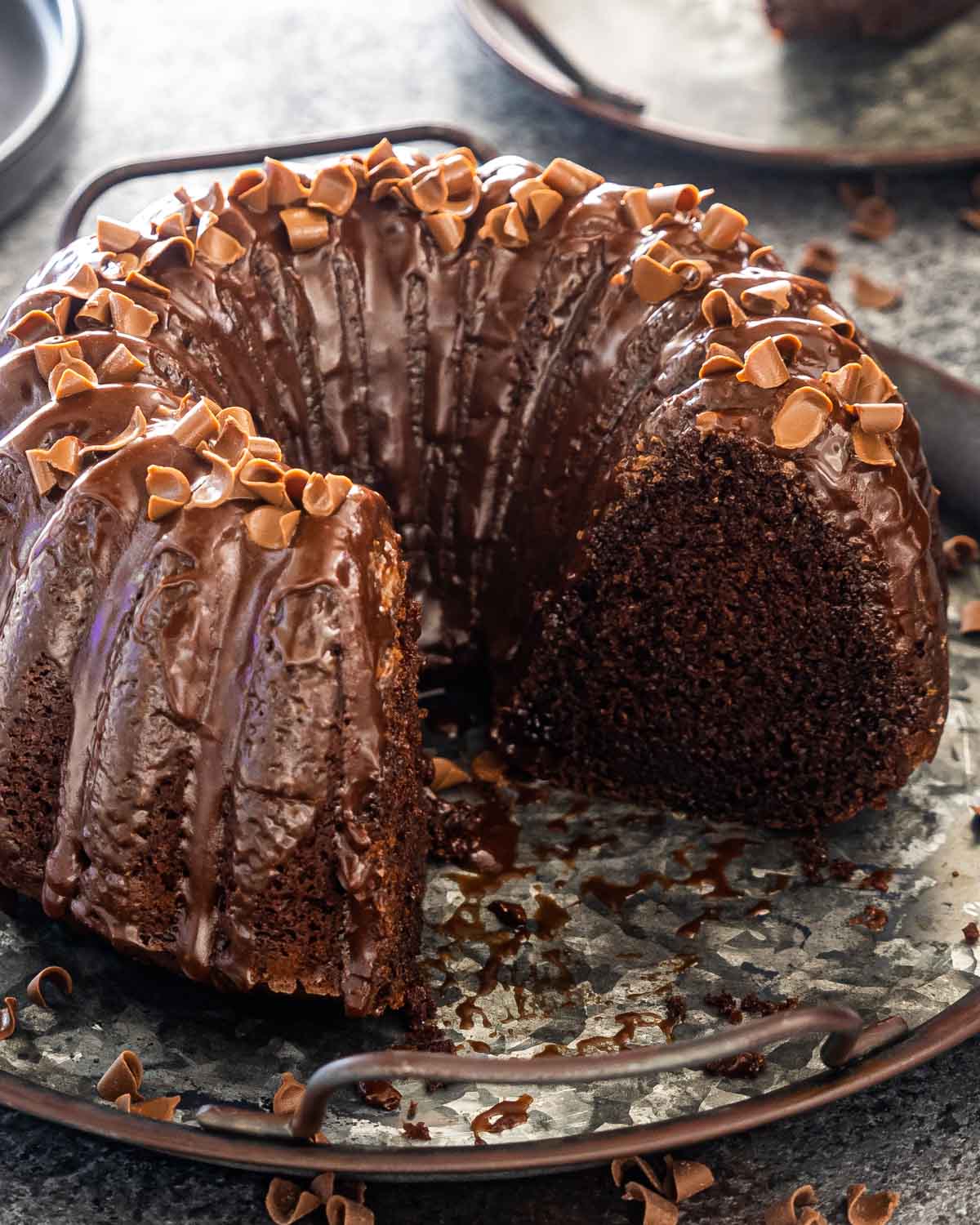 chocolate bundt cake topped with chocolate ganache and sprinkled with chocolate shavings.