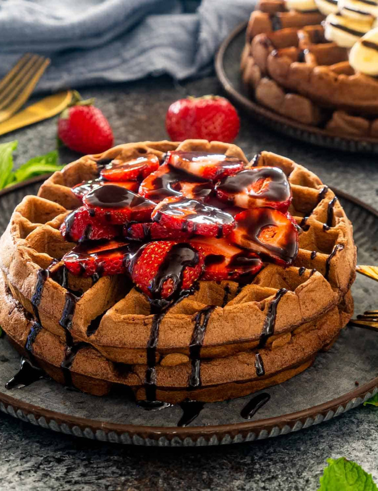 chocolate waffles with strawberries and chocolate sauce.