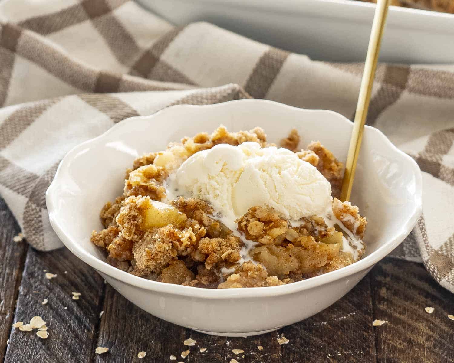 apple crumble and ice cream in a white bowl.
