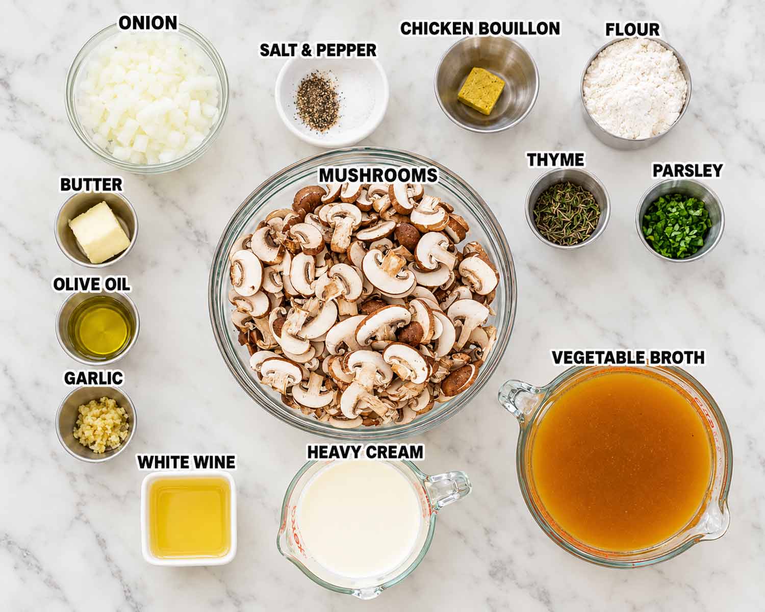 Overhead view of mushrooms, onion, broth, cream, wine, butter, garlic, herbs, and seasonings arranged in labeled bowls.