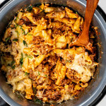 lasagna in an instant pot with a wooden serving spoon inside.
