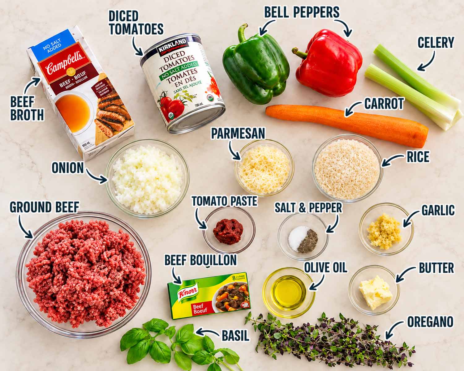 Ingredients for stuffed pepper soup arranged on a beige surface, including ground beef, bell peppers, rice, tomatoes and broth.