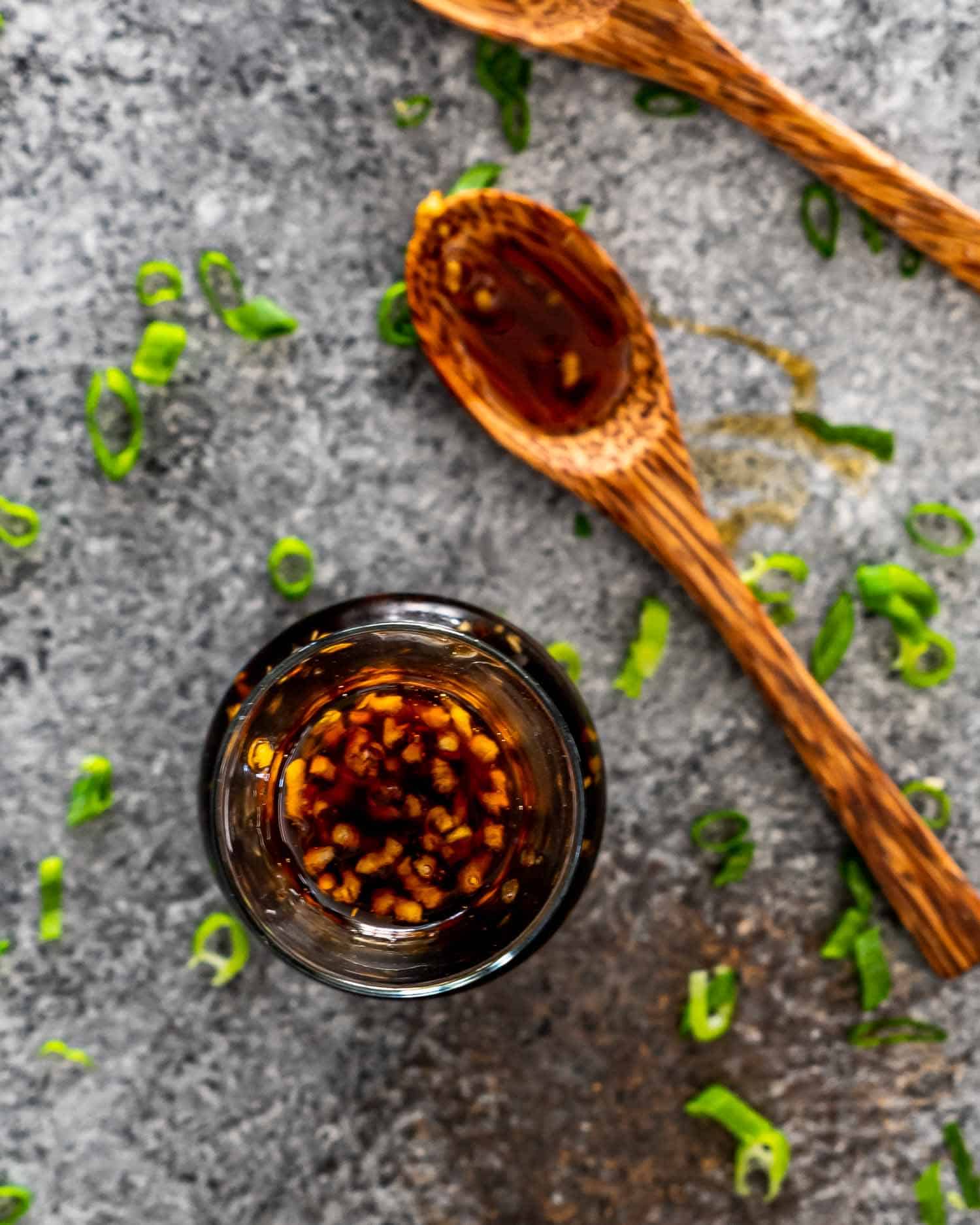 teriyaki sauce in a bottle with a tablespoon with teriyaki sauce.