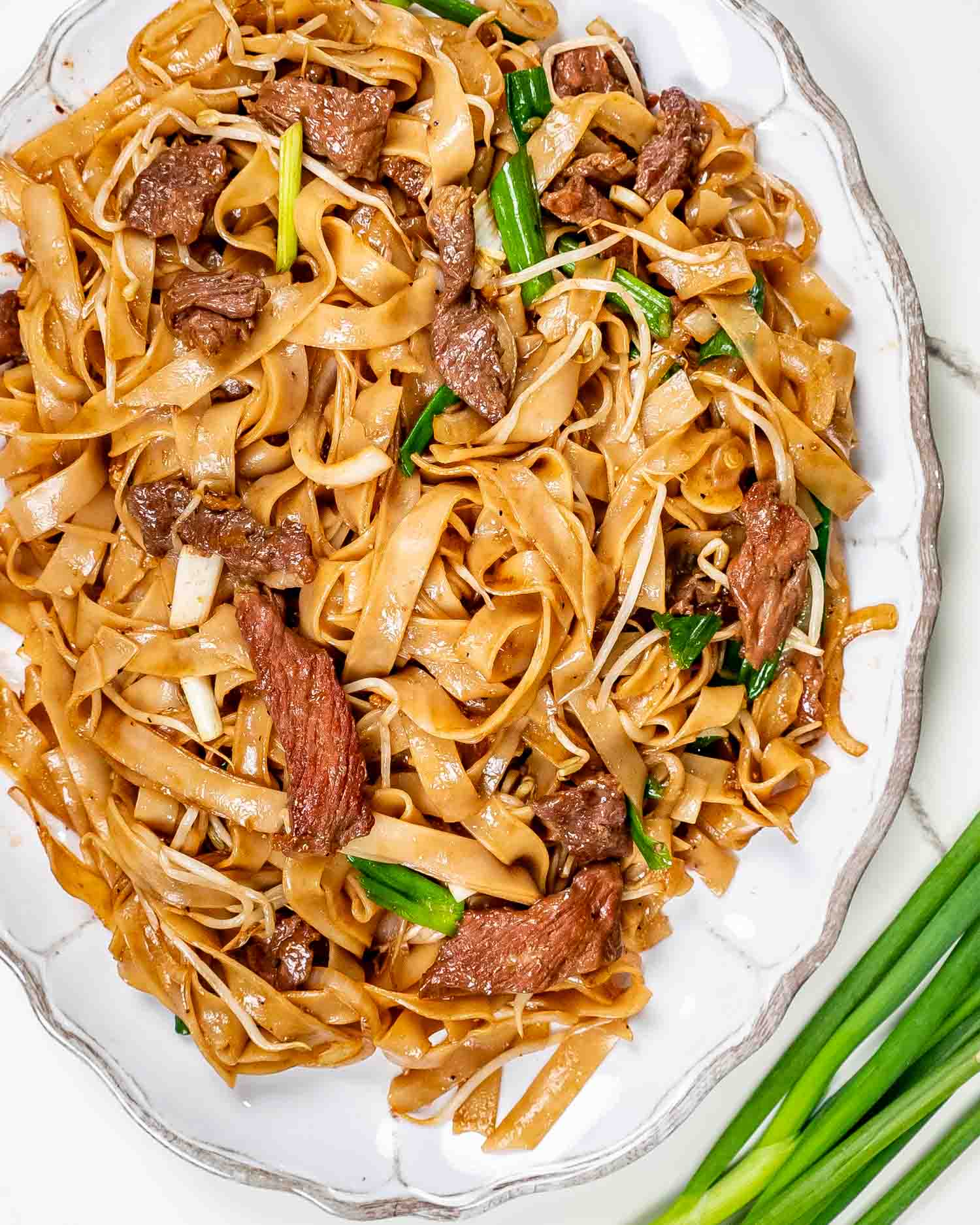 freshly made beef chow fun on a serving platter.