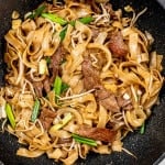 beef chow fun in a black wok.