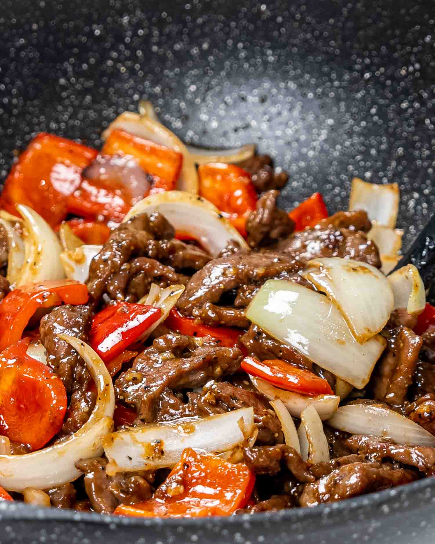freshly made black pepper beef in a wok.