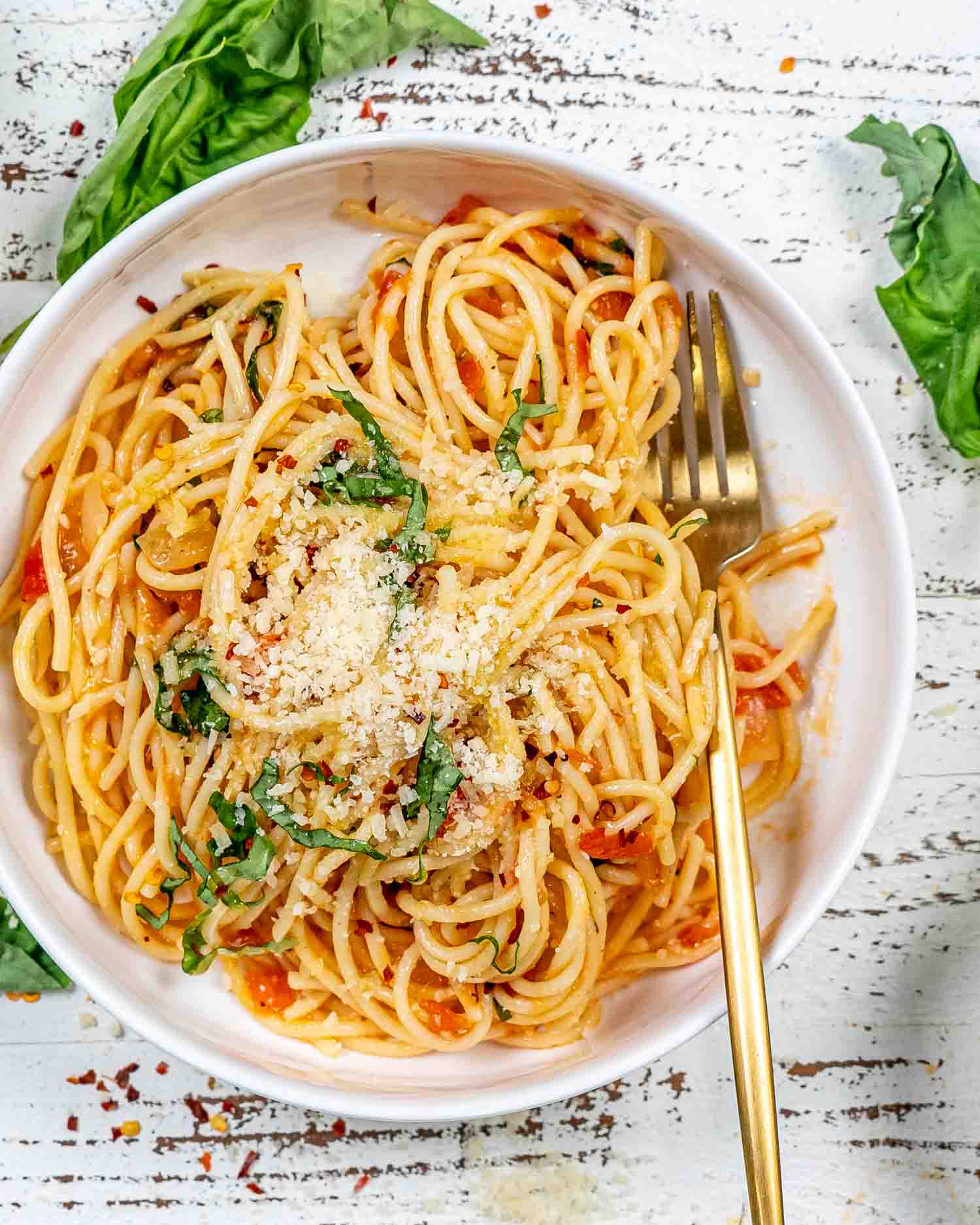 a serving of freshly made pasta pomodoro in a white bowl.