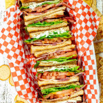 a stack of BLT sandwiches in a basket.