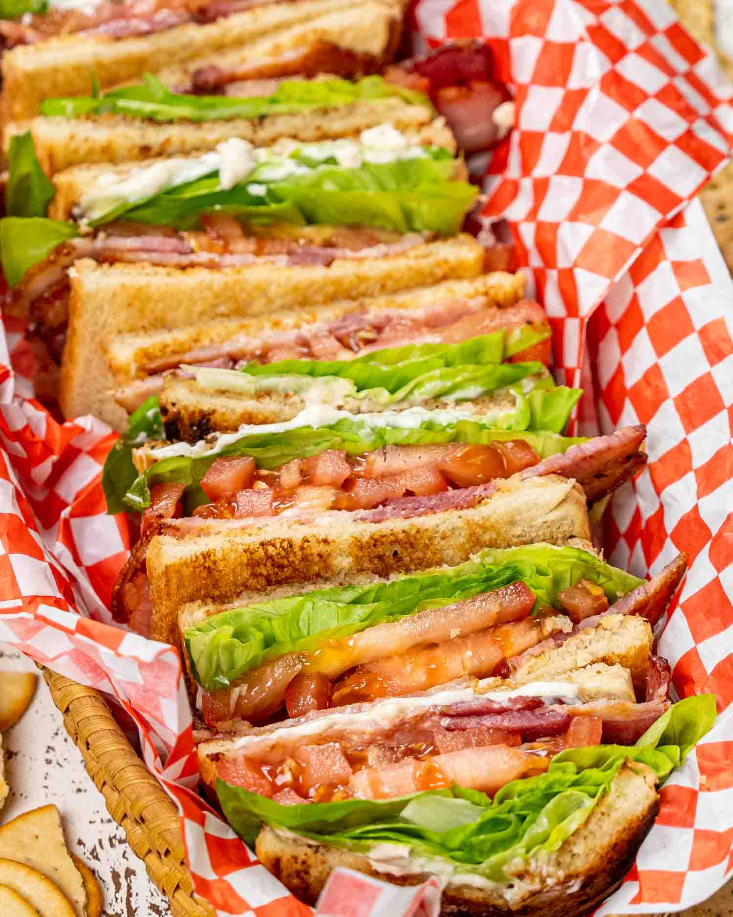 a stack of BLT sandwiches in a basket.