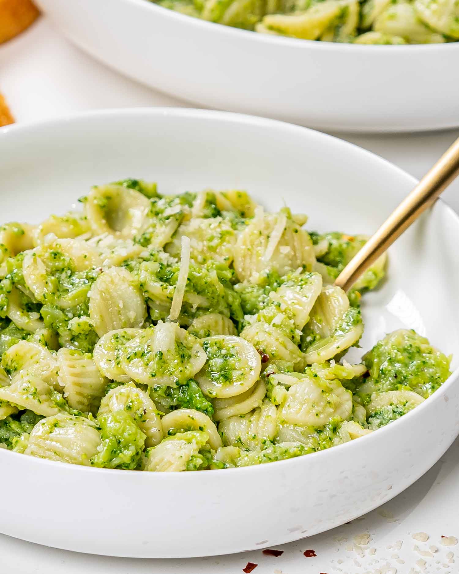 a serving of broccoli pasta in a white bowl.