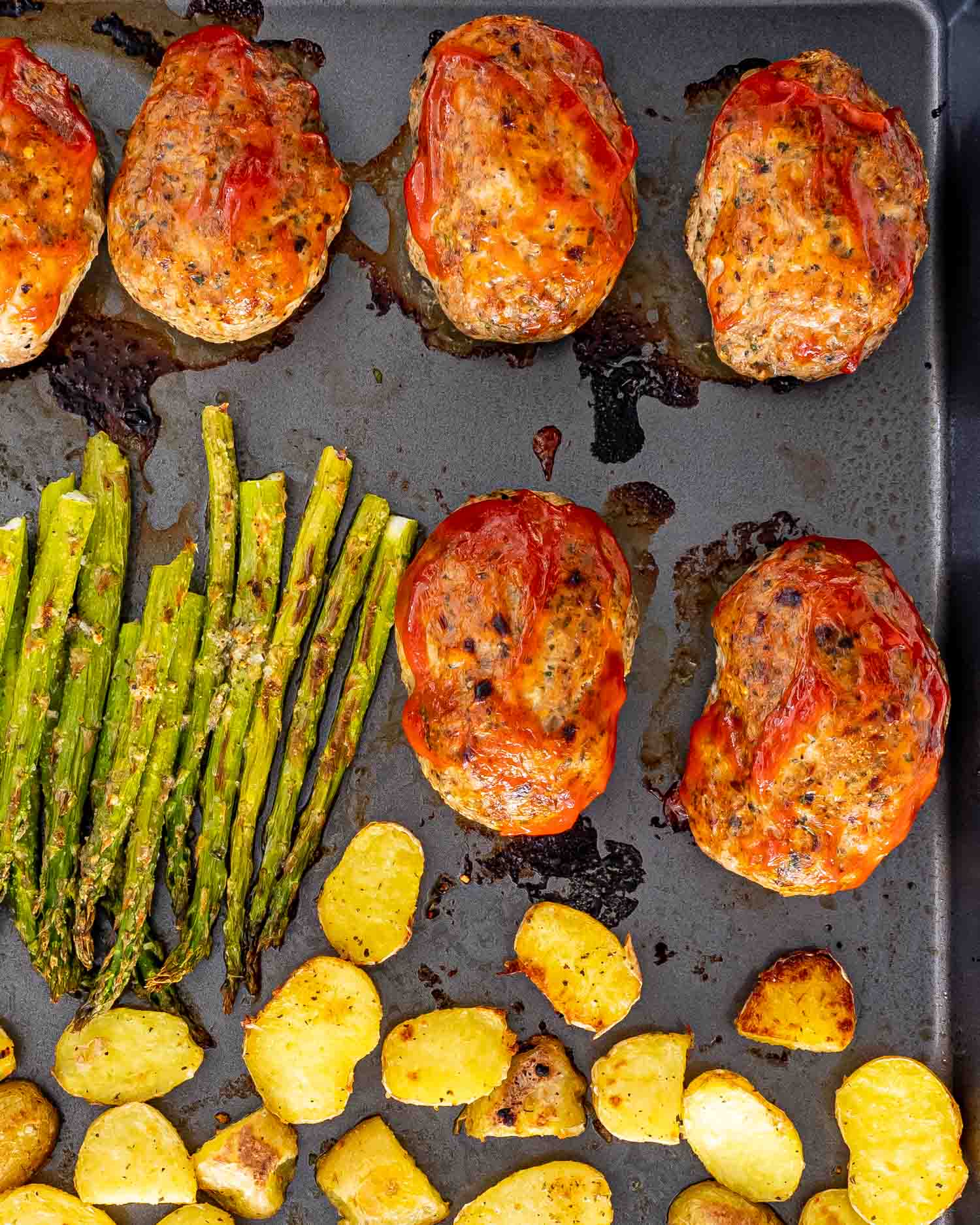 mini turkey meatloaves sheet pan dinner with roasted potatoes and asparagus.