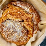 freshly baked no knead honey oat bread in a dutch oven.