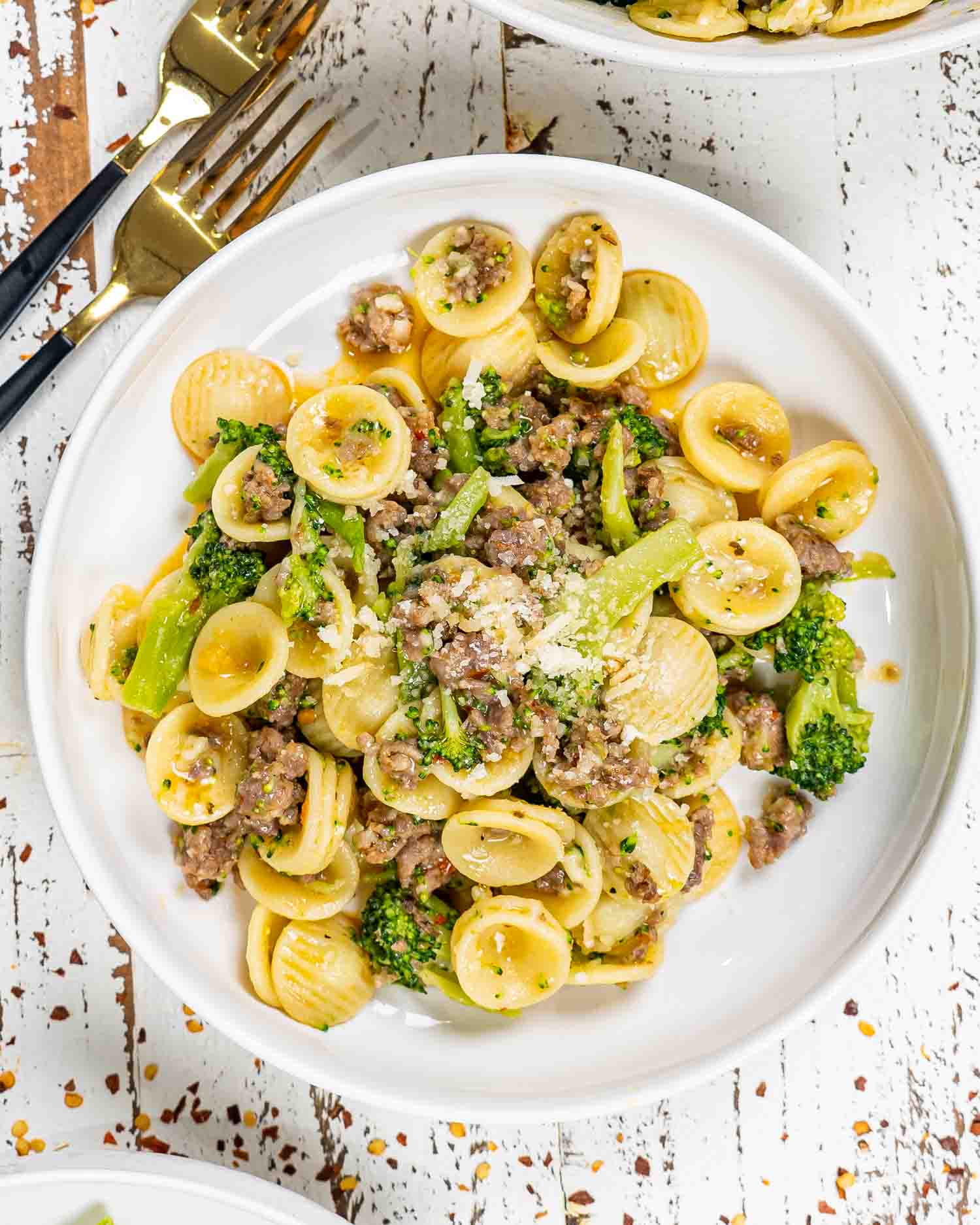 a serving of orecchiette with sausage and broccoli in a white bowl.