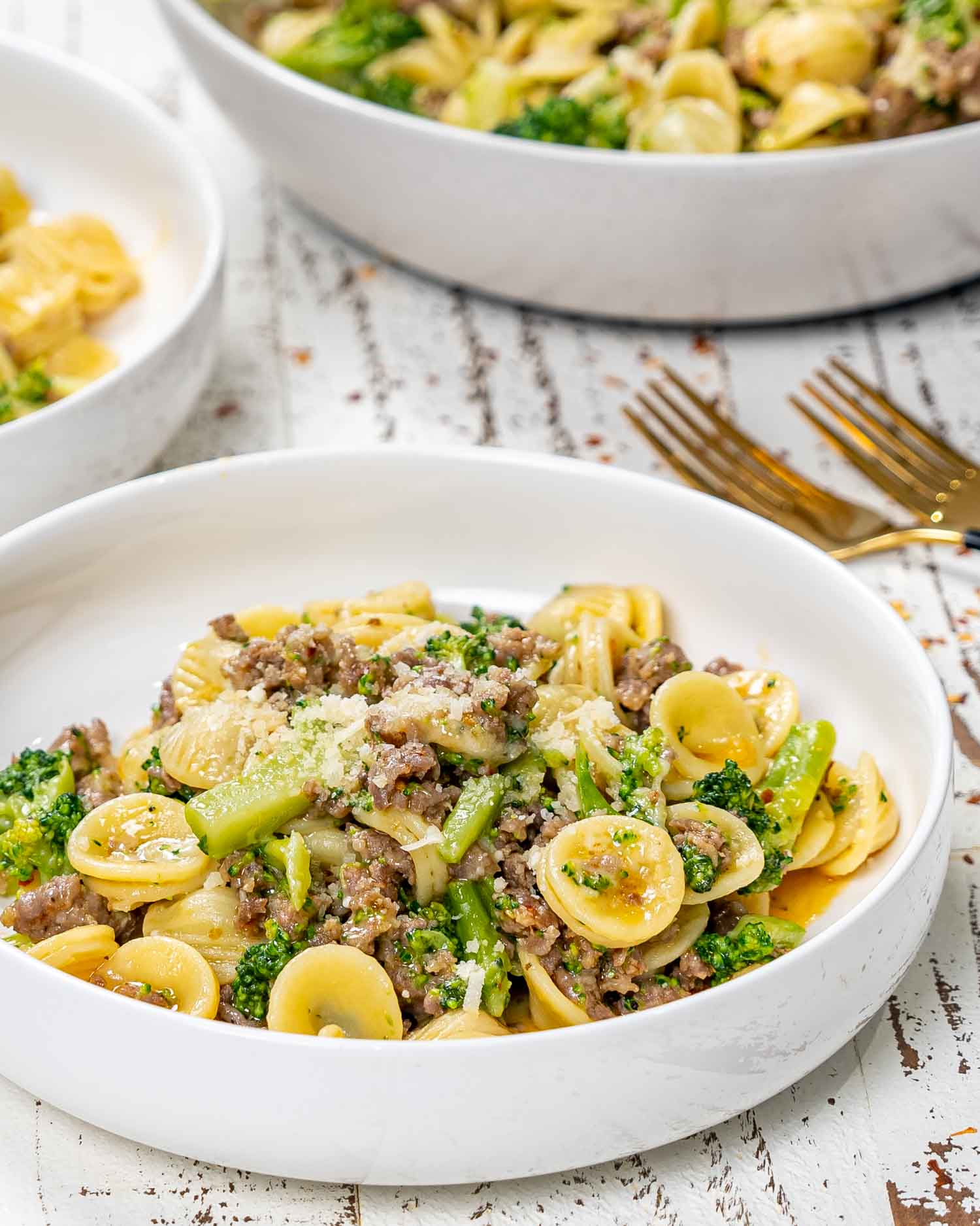 a serving of orecchiette with sausage and broccoli in a white bowl.