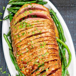 instant pot ham with green beans on a white platter.
