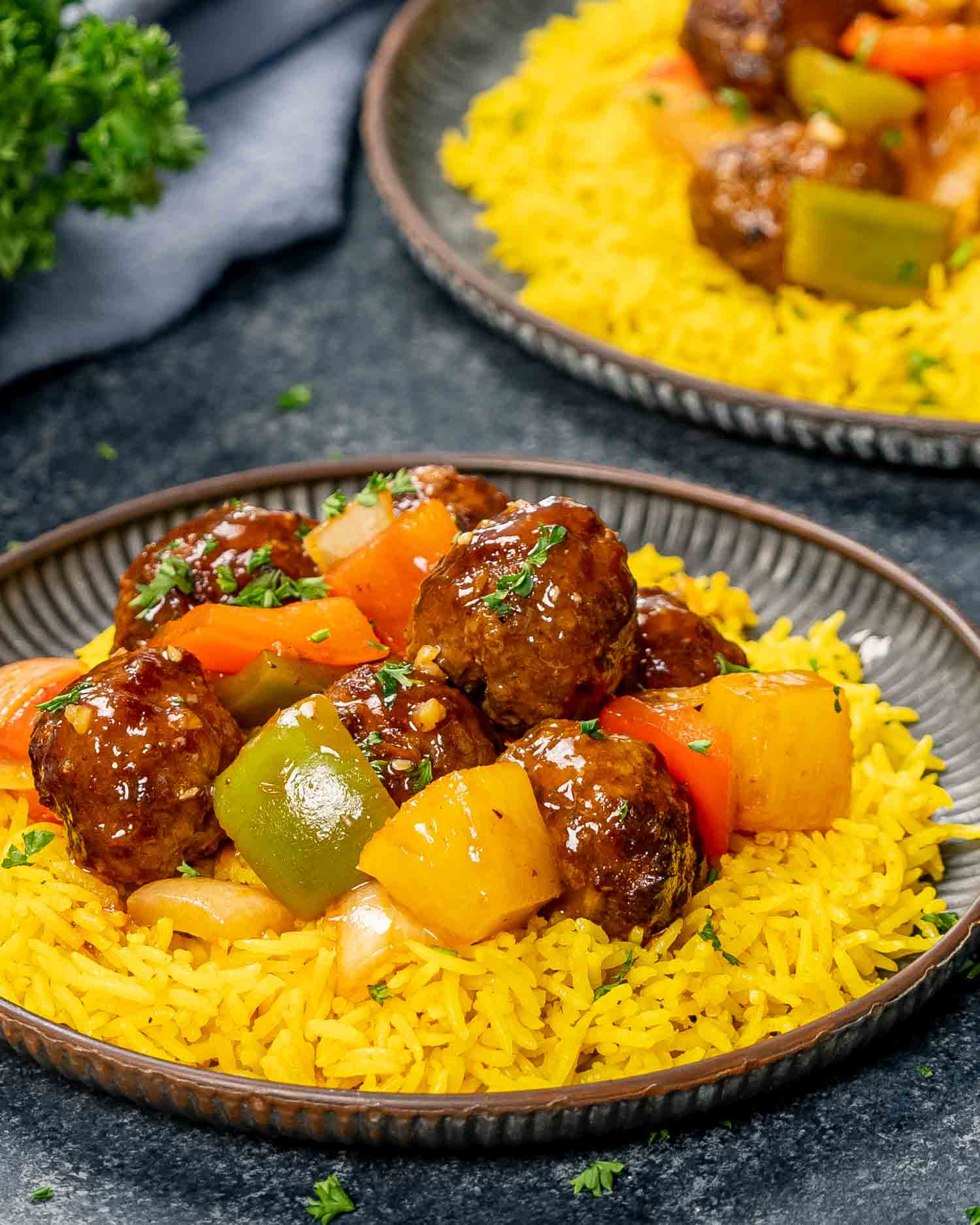 sweet and sour meatballs over a bed of yellow rice.