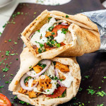 two chicken doner kebabs on a cutting board with a delicious yogurt sauce.