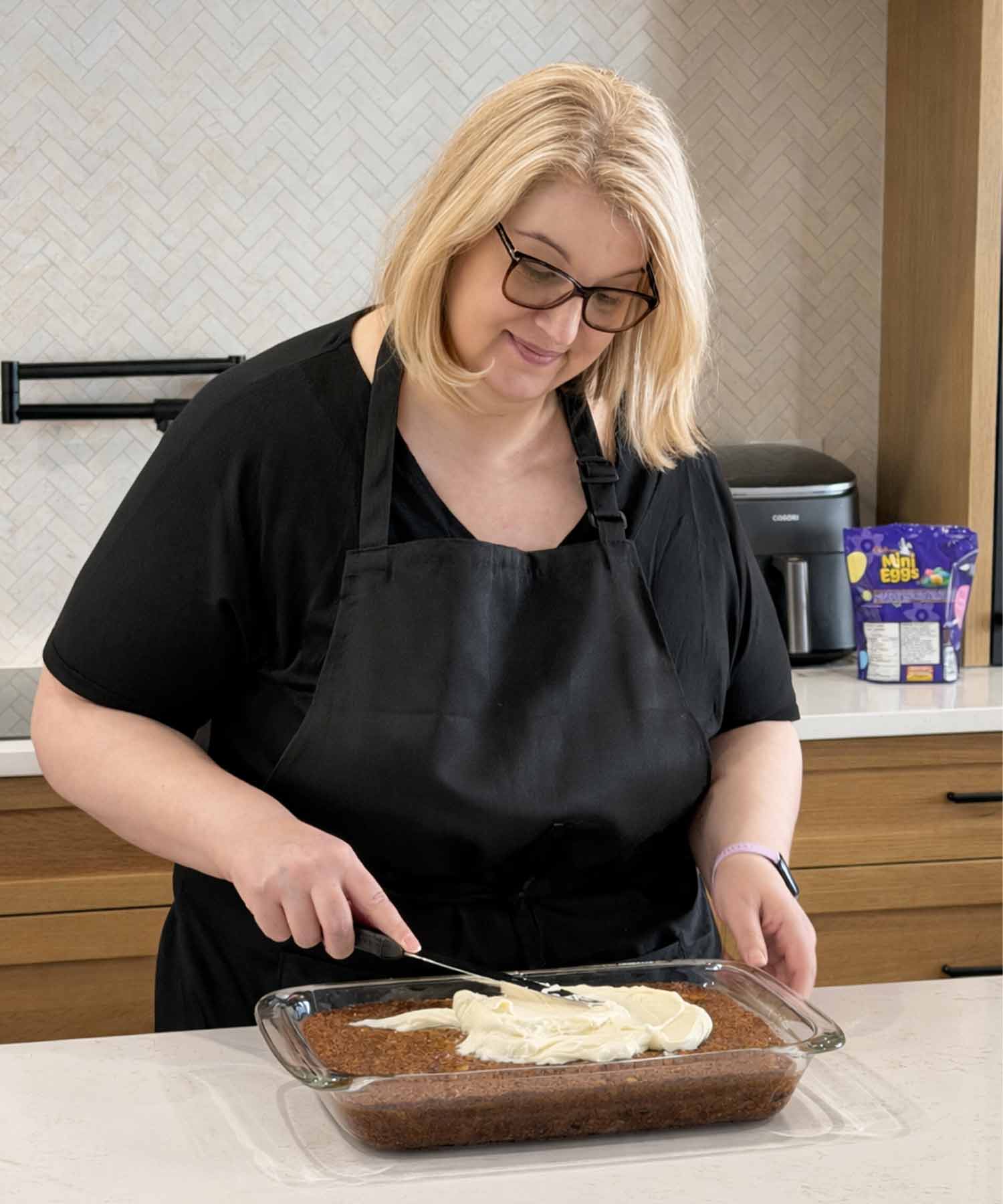 jo frosting a carrot cake.