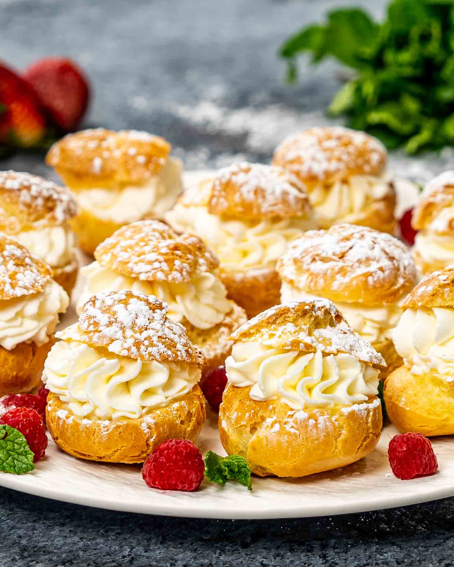 puffs (choux pastry) filled with whipped cream on a platter.