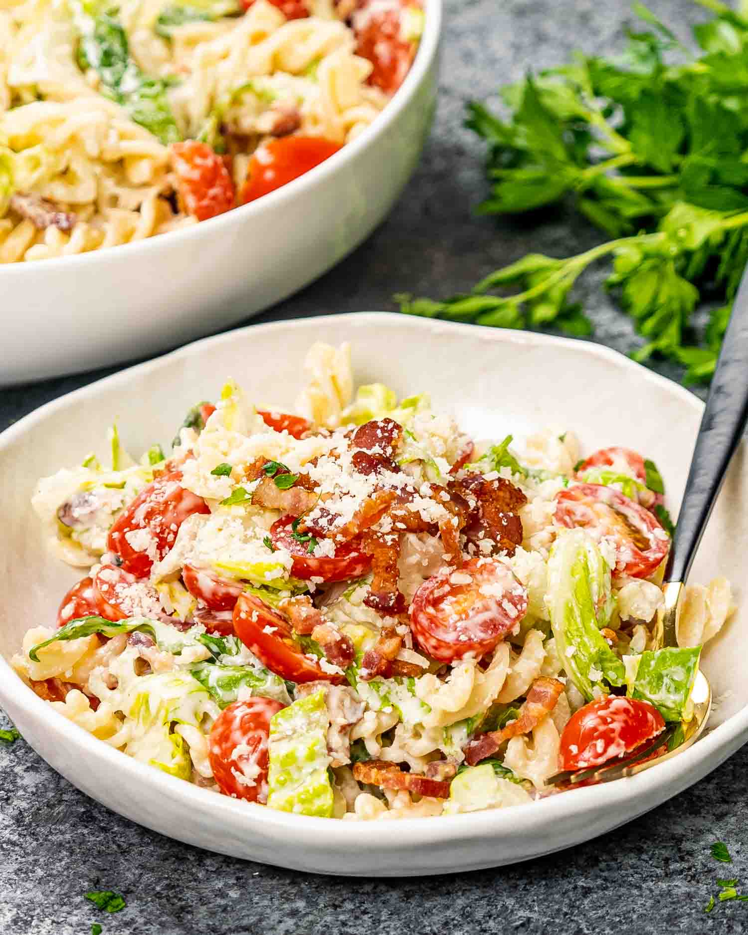 a serving of freshly made blt pasta salad in a white pasta bowl.