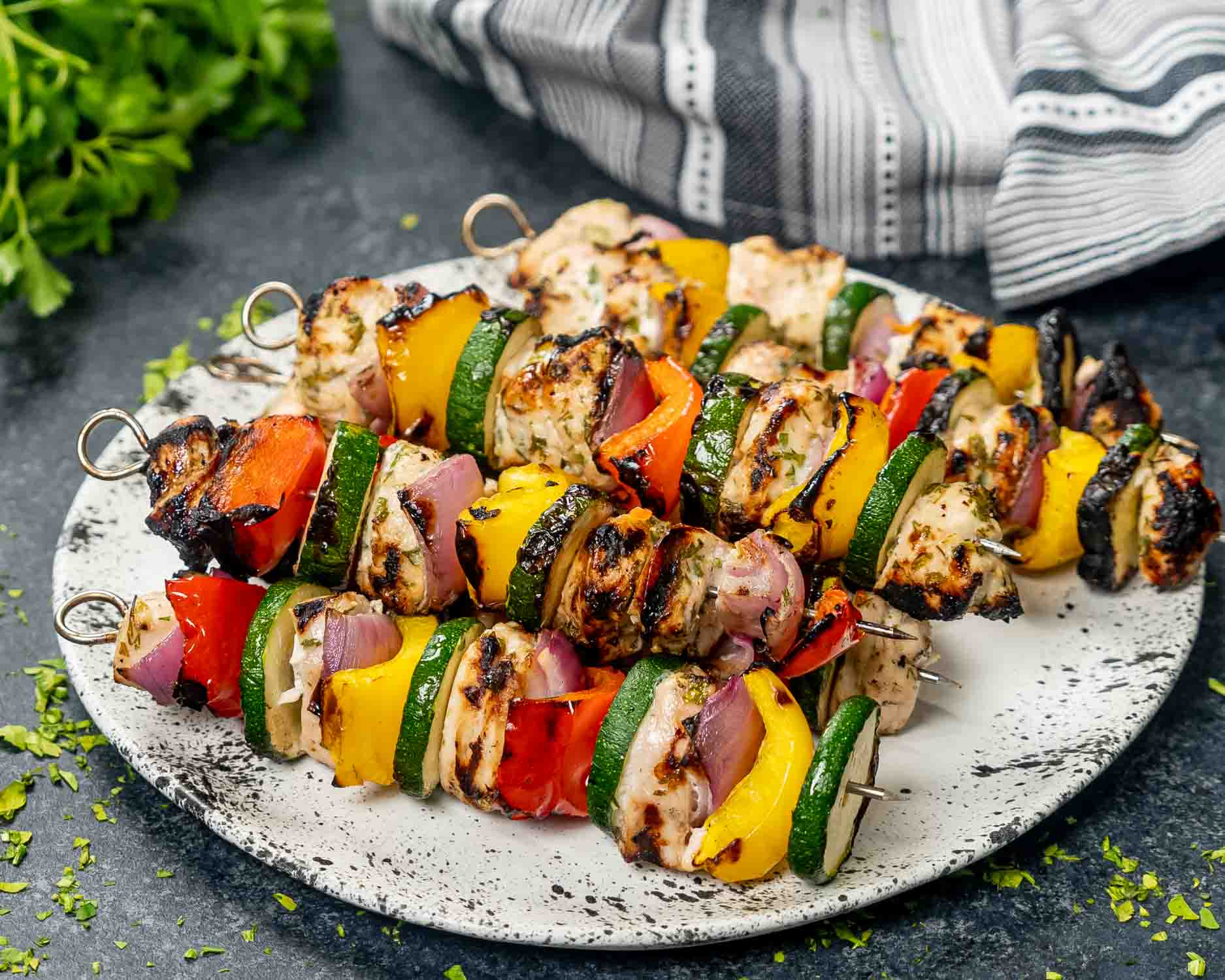 grilled chicken kebabs on a white plate.