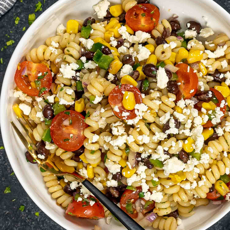 a serving of southwest pasta salad in a white bowl with a fork inside.