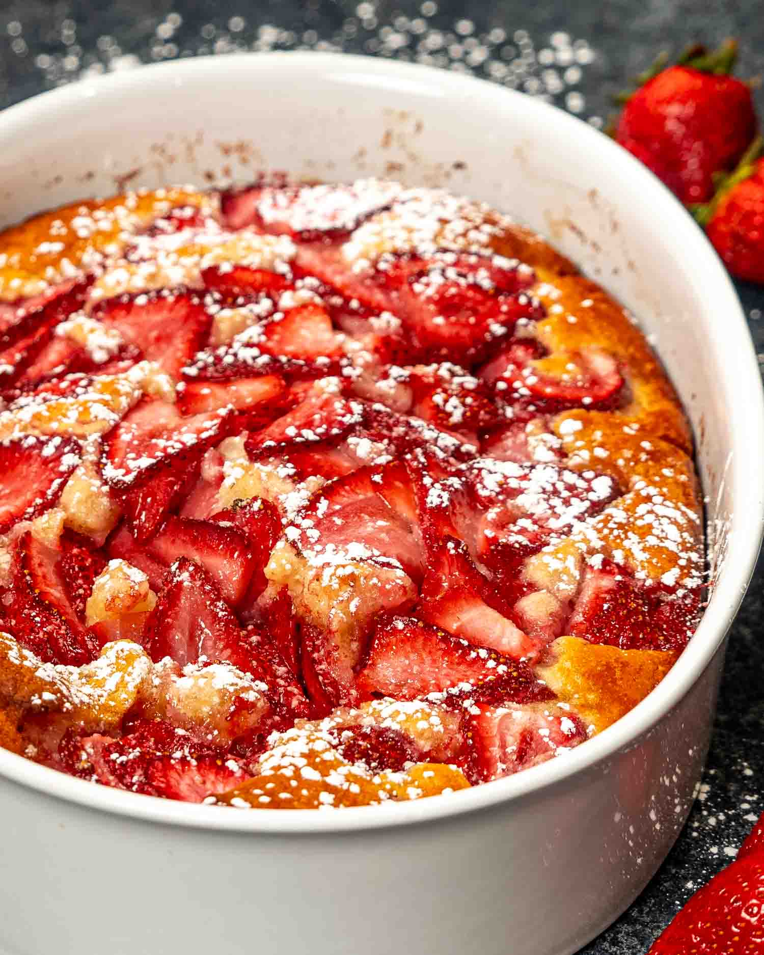 a freshly baked strawberry cobbler in a oval pan.
