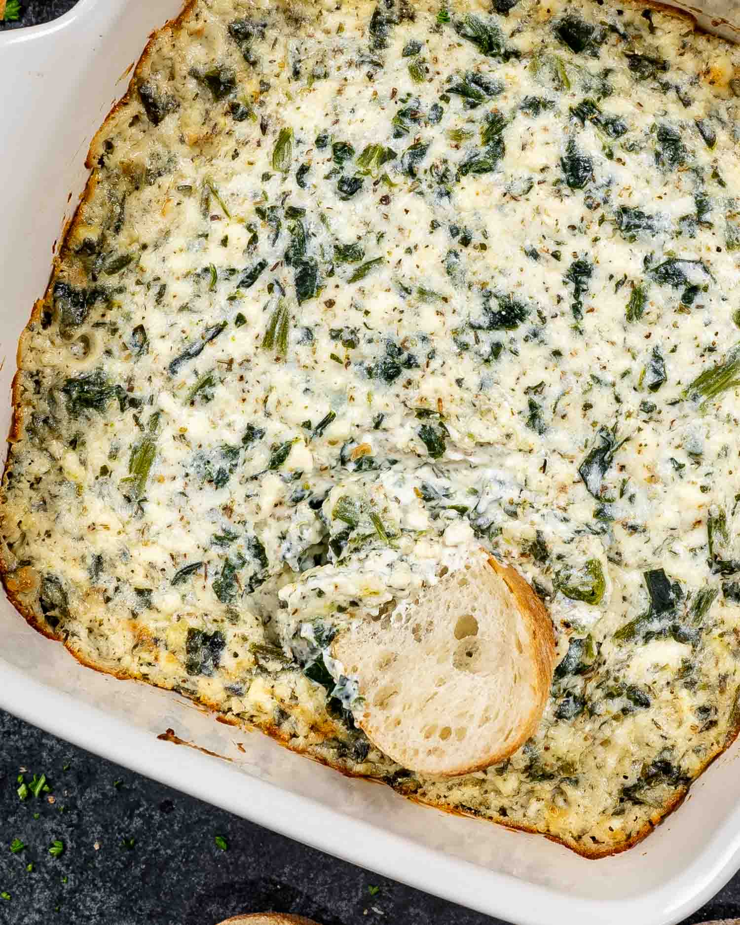 baked feta spinach dip in a square casserole dish.