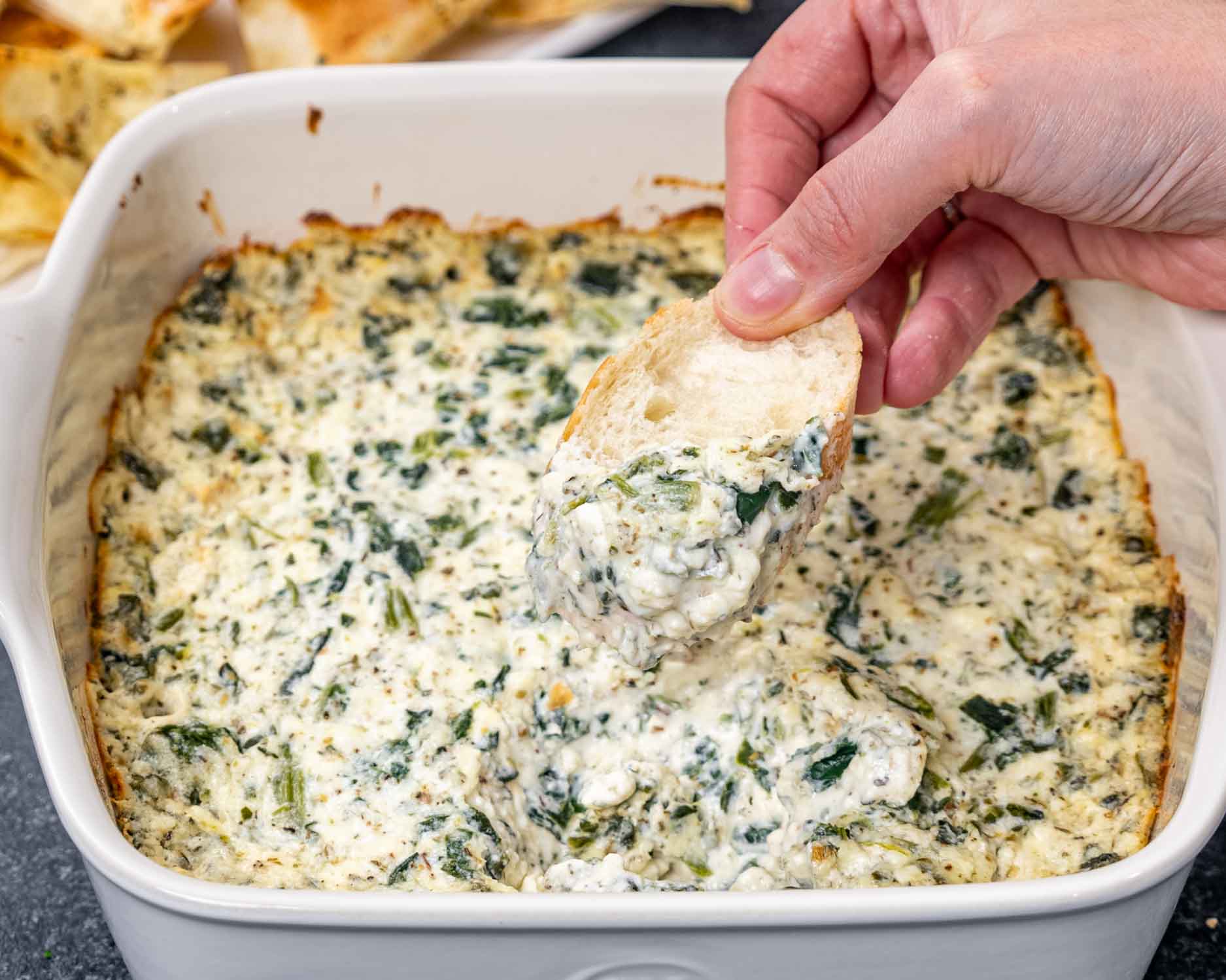 baked feta spinach dip in a square casserole dish.