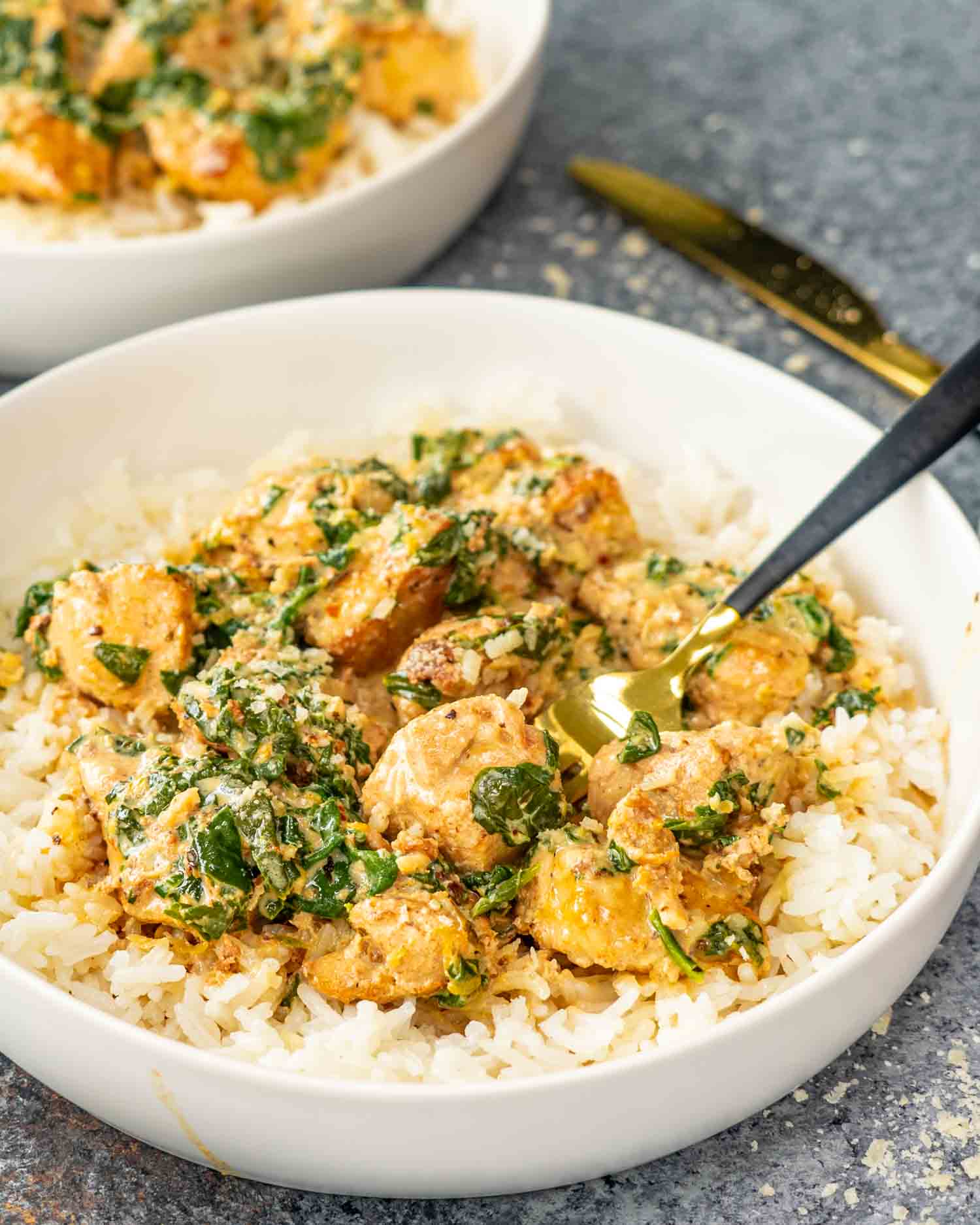 a serving of creamy butter lemon chicken on a bed of rice in a white bowl.