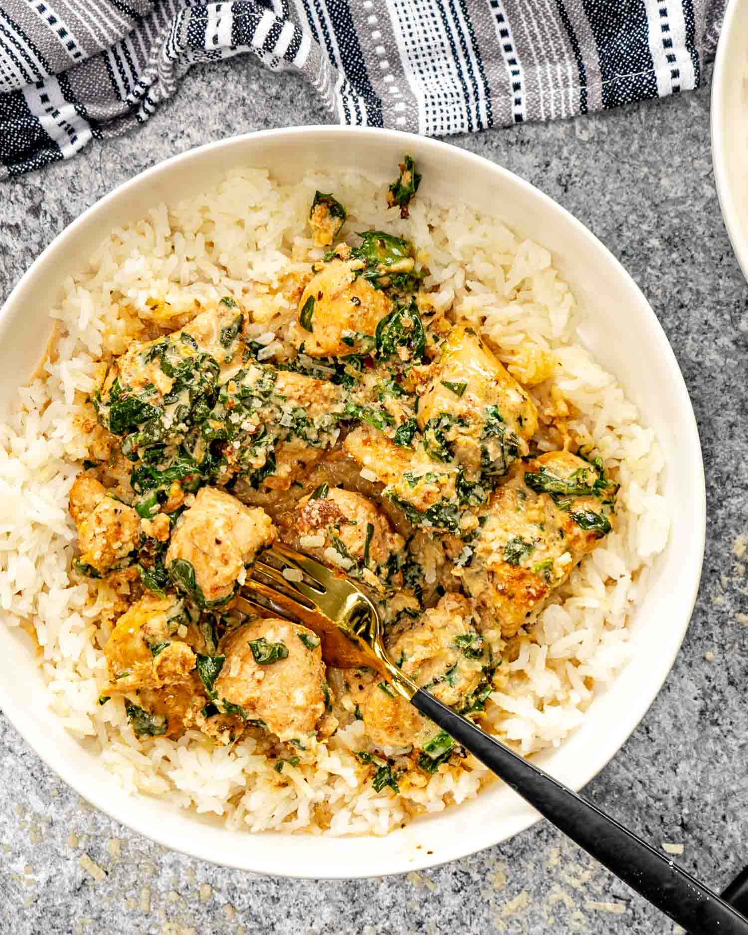 a serving of creamy butter lemon chicken on a bed of rice in a white bowl.