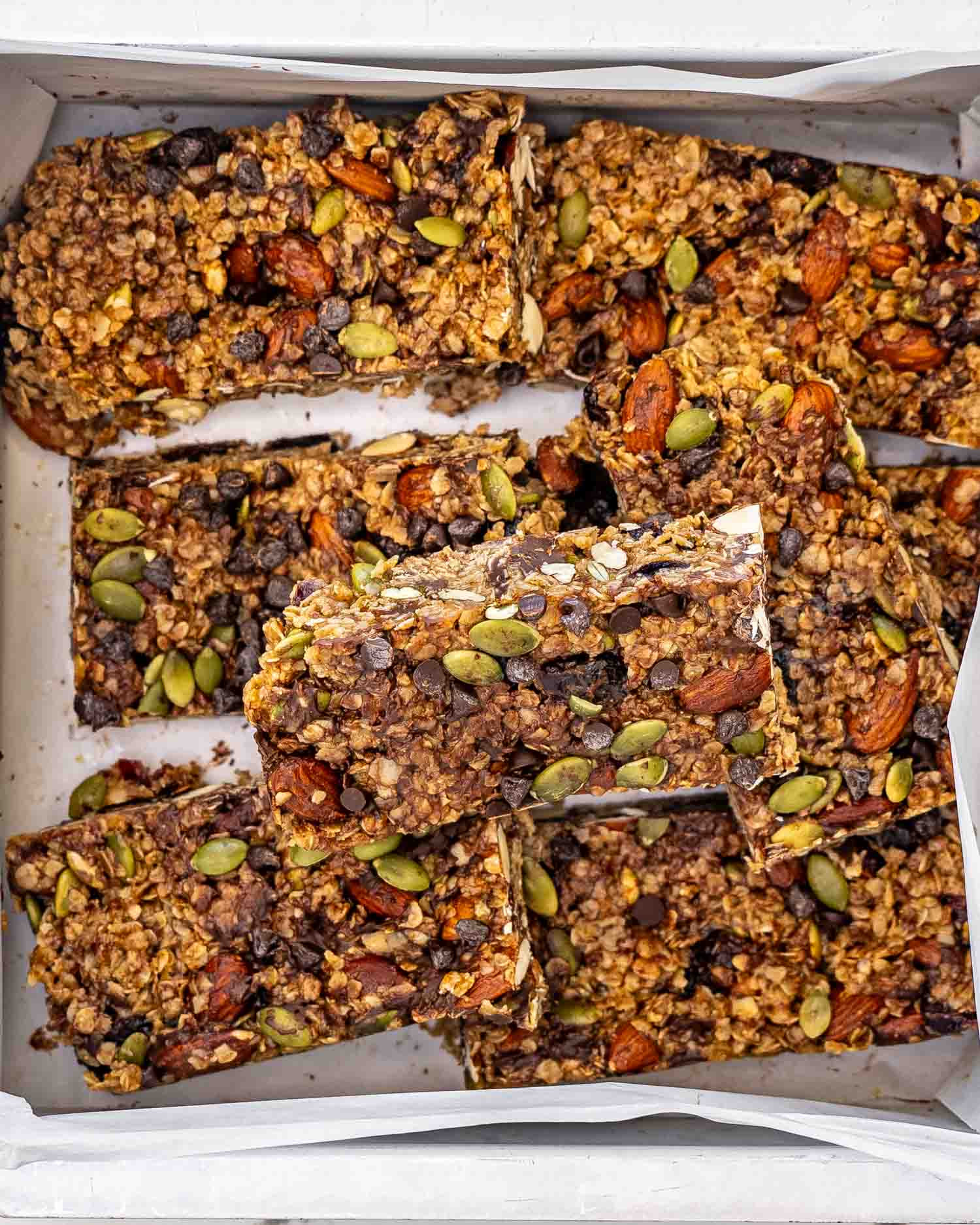 freshly made granola bars all cut up in a square baking dish.